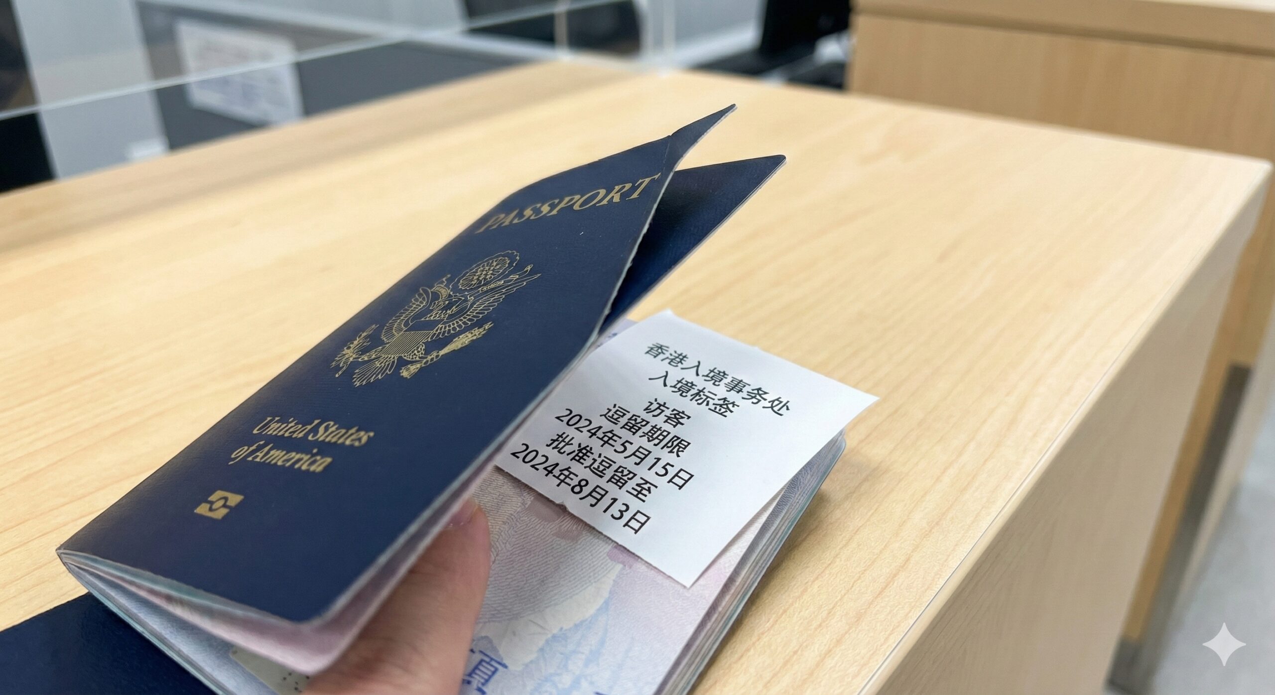 聚焦于香港入境细节的微距特写摄影。画面展示一张香港入境事务处打印的入境标签(Landing Slip)正被夹在美国护照的内页中,标签上清晰可见'Visitor'及'Limit of stay'等字样,暗示90天的免签停留期。背景是干净整洁的海关柜台表面,光线明亮清晰,风格严谨客观,旨在直观展示免签入境后的具体凭证形式。